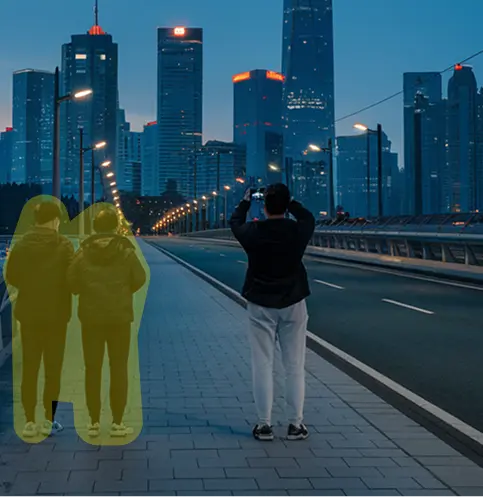 Two highlighted people selected for removal from a city bridge photo at dusk